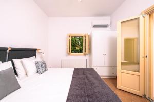 a white bedroom with a bed and a window at White Orchid Villa in Pirgos +68 photos