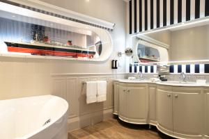 a bathroom with two sinks and a boat in a mirror at Hotel Le Negresco in Nice