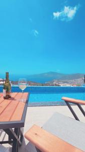 ein Glas Wein auf einem Tisch neben einem Pool in der Unterkunft Ada Villa in Kalkan
