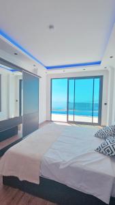 ein Schlafzimmer mit großem Bett und Blick auf das Meer in der Unterkunft Ada Villa in Kalkan
