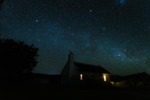 ein Haus unter einem Sternenhimmel in der Nacht in der Unterkunft Alpha Excelsior Guest Farm in Cederberg