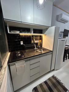 a small kitchen with a sink and a stove at K Fofo - Aconchego no Centro in Rio de Janeiro