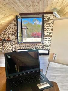 a laptop computer sitting on a table in front of a window at Etape en Barétous - 6 personnes in Aramits +6 photos