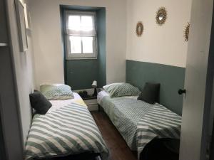 two beds in a small room with a window at Etape en Barétous - 6 personnes in Aramits