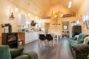 a living room and kitchen in a log cabin at Domek Pan Modrzew - ogrodzony teren Pet Friendly in Zachełmie