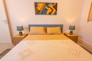 a bedroom with two beds and two lamps on tables at Penthouse Cathedral and Seaview Terrace V2 in Valletta