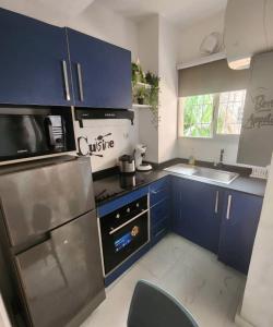 a kitchen with blue cabinets and a stainless steel refrigerator at Over cloud 1 in Marcory +21 photos