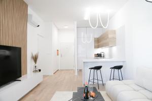 a white living room with a white couch and stool at Kesselbauer Bratislava - luxury apartment with free parking in Bratislava