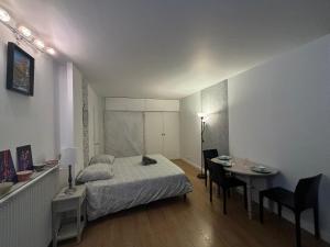a bedroom with a bed and a table and a desk at Appartement des Champs Elysées in Paris