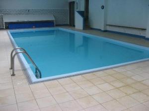 a large blue swimming pool in a building at Sea-Zen De Panne in De Panne