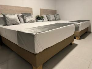 two beds sitting next to each other in a bedroom at Hotel Med Llanogrande in Rionegro +22 photos