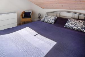 Un dormitorio con una cama con sábanas moradas y una silla en Haus Birkenmeier, en Freiburg im Breisgau