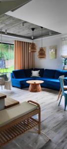 a living room with a blue couch and a table at Wyskocz w góry - domek z balią ogrodową in Szczyrk +26 photos