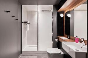 a bathroom with a shower and a toilet and a sink at Moxy Amiens in Amiens