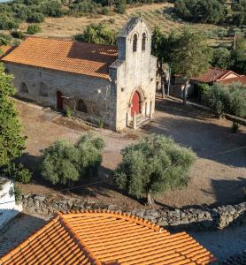 an old church with a red door and orange tile roofs at Casa da Igreja by Casas do Planalto in Adeganha