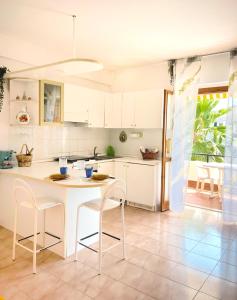 a kitchen with white cabinets and a table and chairs at EC apartment in Scalea