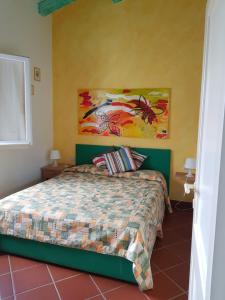 a bedroom with a bed and a painting on the wall at Rotondo Residence - Simar Vacanze in Porto Rotondo