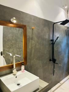 a bathroom with a sink and a mirror and a shower at Villa Carla Mirissa in Mirissa