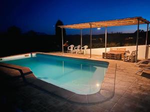 a swimming pool with a pavilion and a table and chairs at Agriturismo Funtan'Arva in Loculi