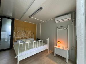 a bedroom with a bed and a lamp on a table at Frutak Resort-TINY HOMES in Danilovgrad