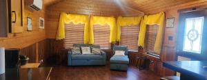 a room with a couch and two chairs in a cabin at MeMaws Country Cabin in Pipe Creek