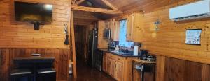 a kitchen in a log cabin with a tv on the wall at MeMaws Country Cabin in Pipe Creek +12 photos