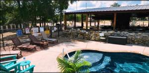 a swimming pool in a yard with chairs and a pavilion at MeMaws Country Cabin in Pipe Creek