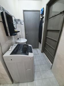 cocina con fogones, fregadero y puerta en Teratak Ayuni with Private pool, en Batu Gajah