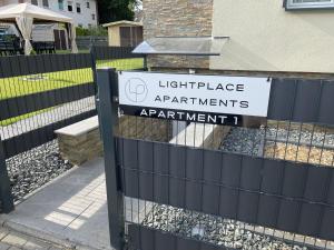 ヴォルフスブルクにあるLightplace - Boxspring - Parkplatz- Nähe City und VWの灯台のあるフェンスの看板、アパートの看板