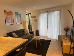 un soggiorno con un divano e un tavolo di Appartement T2 Pyla-sur-mer a La Teste-de-Buch