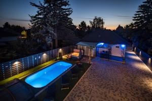 a swimming pool in a backyard at night at Balatonic Lime apartmanház in Siófok