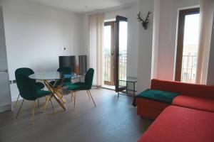 Una sala de estar con un sofá, una mesa y sillas. en Luxury Flat 1 Bedroom Flat I Working Professionals & Contractors I Flat 86, en Saint Albans