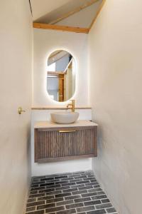a bathroom with a sink and a mirror at Luxe vakantiehuis in dijkboerderij in Zuid-Beijerland