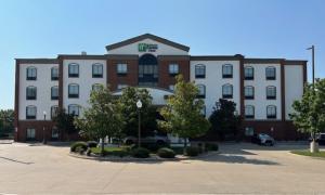 Un gran edificio blanco y rojo con estacionamiento. en Holiday Inn Express Hotel & Suites Ennis by IHG, en Ennis