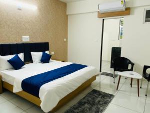 een slaapkamer met een bed met blauwe en witte lakens bij Hotel Balaji Villa in Vadodara