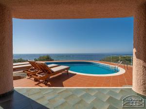 a patio with a chair and a swimming pool at Villa Marisa in Torre delle Stelle