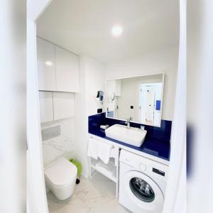 ein Badezimmer mit Waschmaschine und Waschbecken in der Unterkunft Семейный люкс на первой линии in Batumi + 2 Fotos