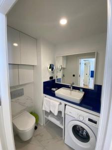 ein Badezimmer mit Toilette, Waschbecken und Waschmaschine in der Unterkunft Семейный люкс на первой линии in Batumi