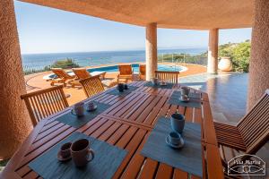 a wooden table with cups and chairs on a deck at Villa Marisa in Torre delle Stelle