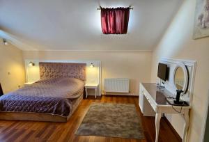 a bedroom with a bed and a desk with a mirror at Helen Hotel in Mykolaiv