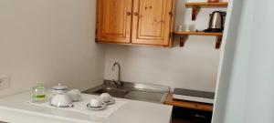 a kitchen counter with cups and saucers and a sink at Panorama City in Conversano