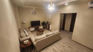 a living room with a couch and a tv at Luxury apartment with balcony, City view in Jeddah