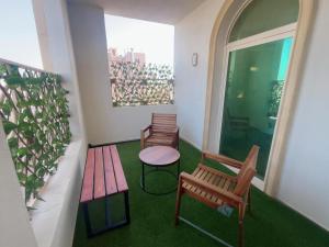 a balcony with two benches and a table and a window at Luxury apartment with balcony, City view in Jeddah