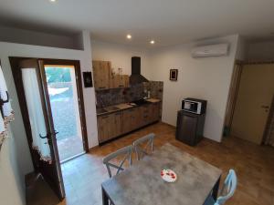 a living room with a table and a kitchen at Agriturismo Campo alla Cantina appartamento Papavero-Malva in Gavorrano +38 photos