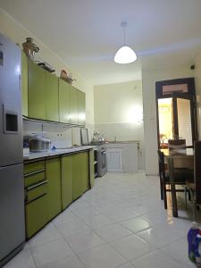 a kitchen with green cabinets and a table in it at Lile in Batumi