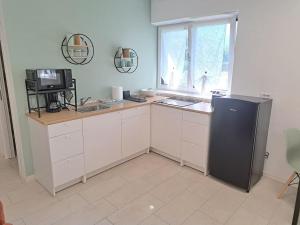 a kitchen with a black refrigerator and a window at Esther house monolocale in Terlano