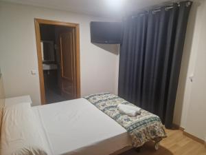 1 dormitorio con cama y cortina negra en Canon,che, en Alcántara de Júcar