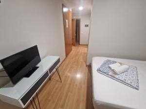 Una habitación con una cama y un escritorio con televisión. en Canon,che, en Alcántara de Júcar
