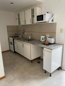 una cocina con fregadero y microondas en Duplex con Excelente ubicación, en Esquel