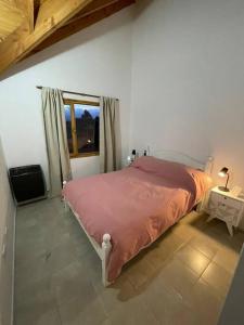 Un dormitorio con una cama y una ventana en Duplex con Excelente ubicación, en Esquel